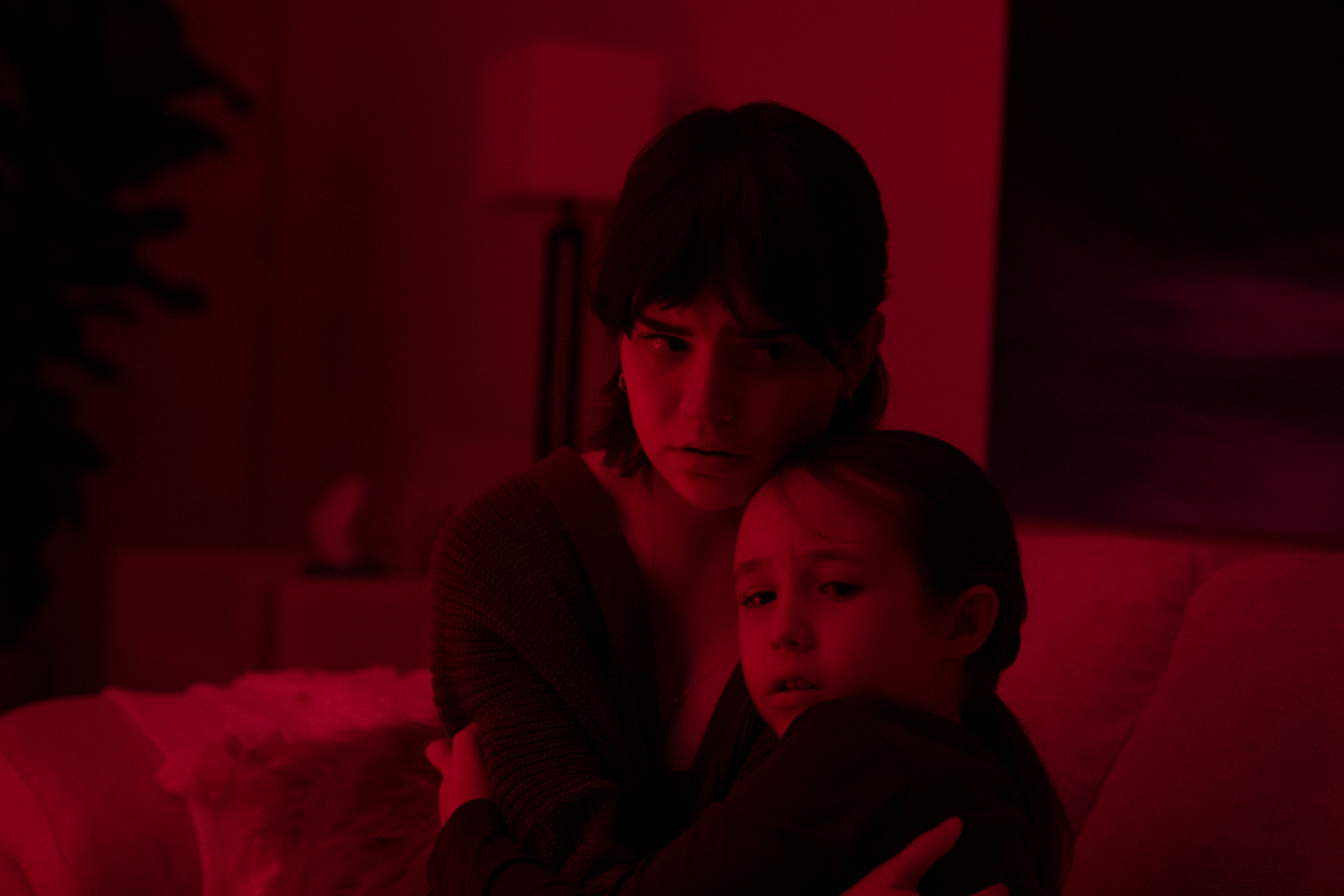 Sadie abraça Sawyer em uma sala iluminada de vermelho em The Boogeyman.