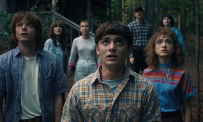 The cast of stranger things stand next to each other and look up.