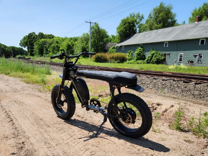 Super73-S Adventure parked by railroad tracks.