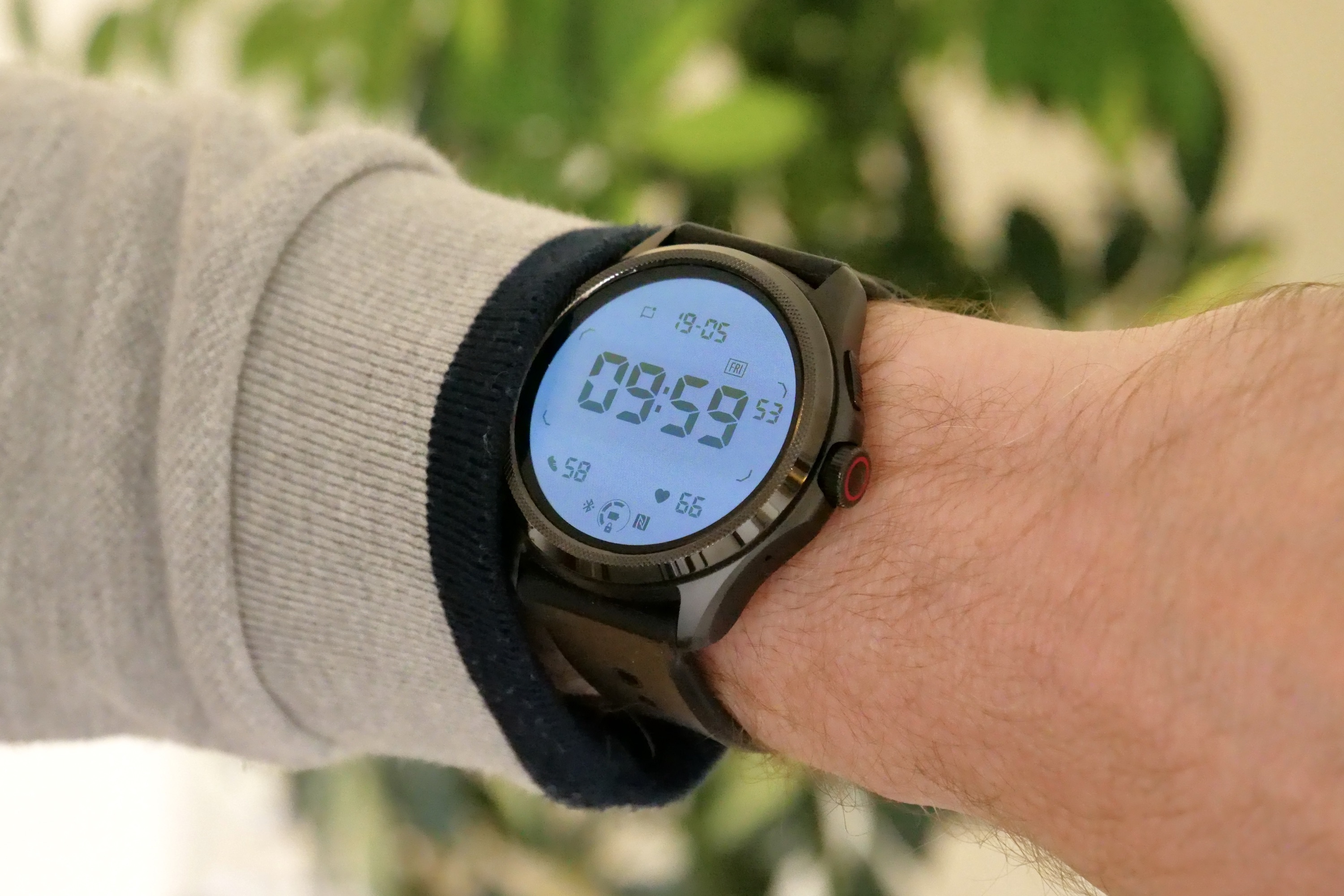 The Mobvoi TicWatch Pro 5 on a person's wrist, showing the backlit secondary screen.