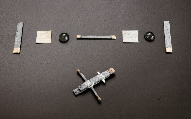 Os componentes de um transistor de madeira dispostos sobre uma mesa.
