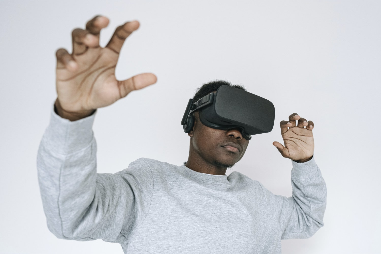 Uma pessoa usando um fone de ouvido de realidade virtual contra um fundo branco.