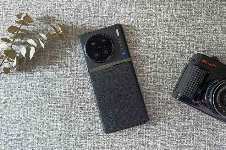 Vivo X90 Pro with Yashica analog camera on a flat surface.