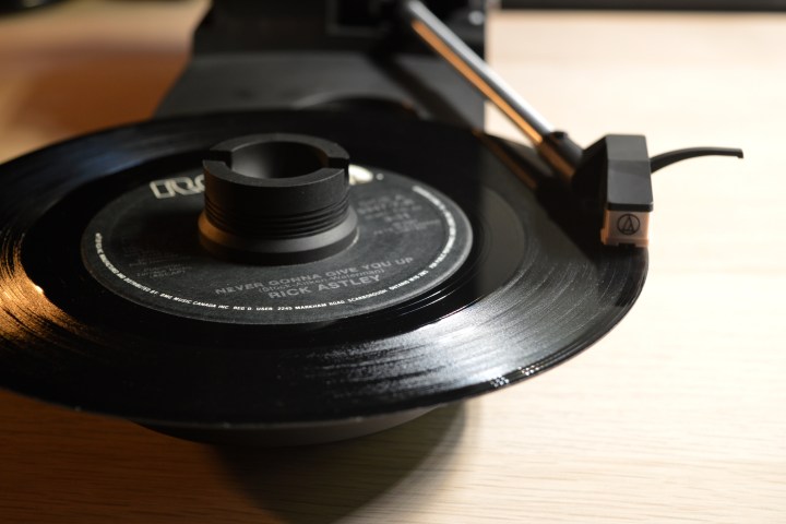 Audio-Technica AT-SB727 Sound Burger riproduce un disco a 45 giri, coperchio aperto.