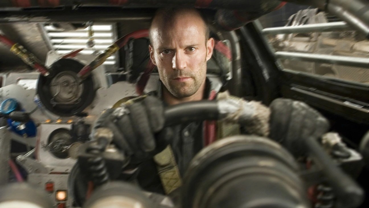 Jason Statham está sentado ao volante de um carro em Death Race.