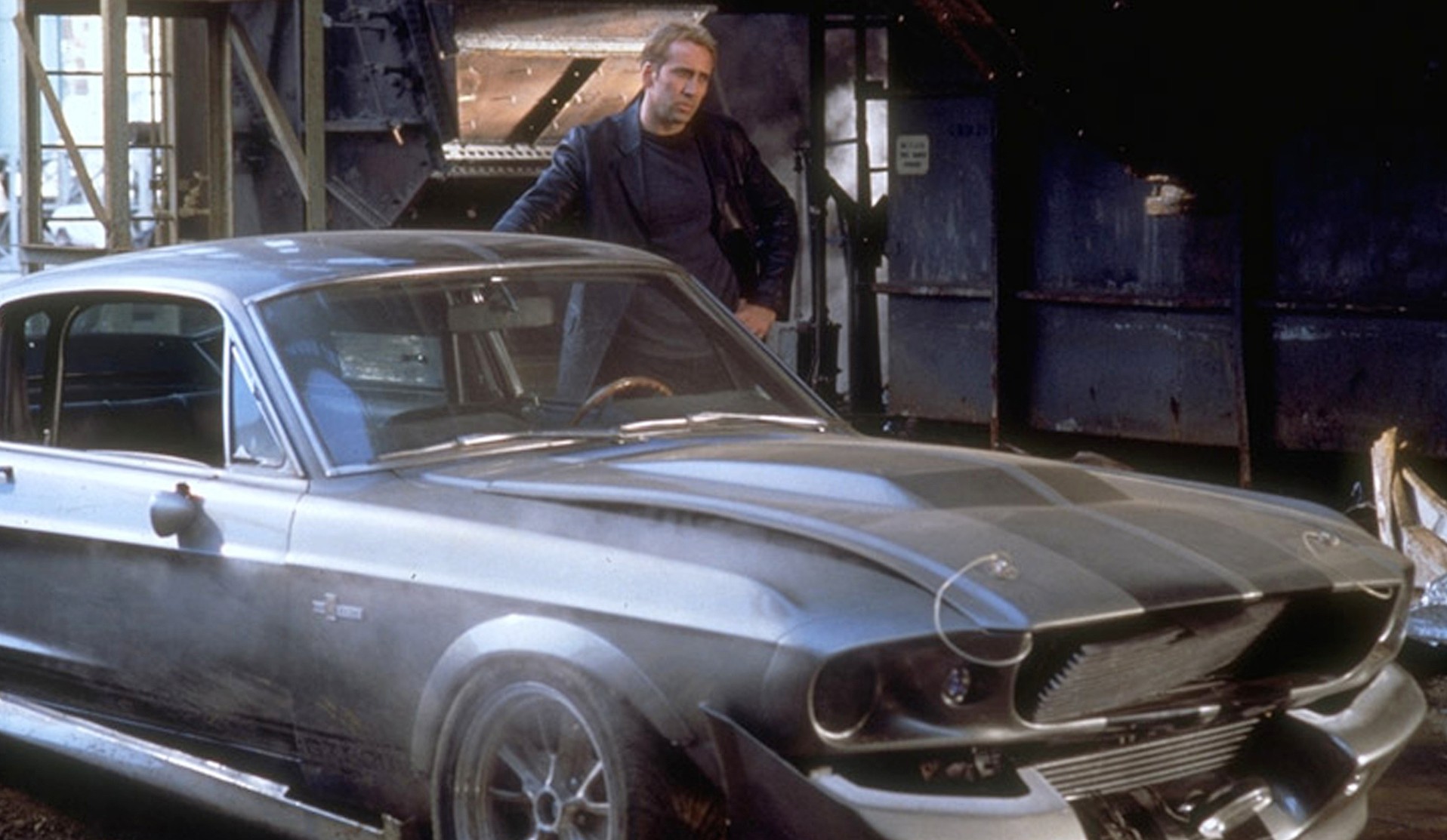 Nicolas Cage está ao lado de um carro em Gone in 60 Seconds.