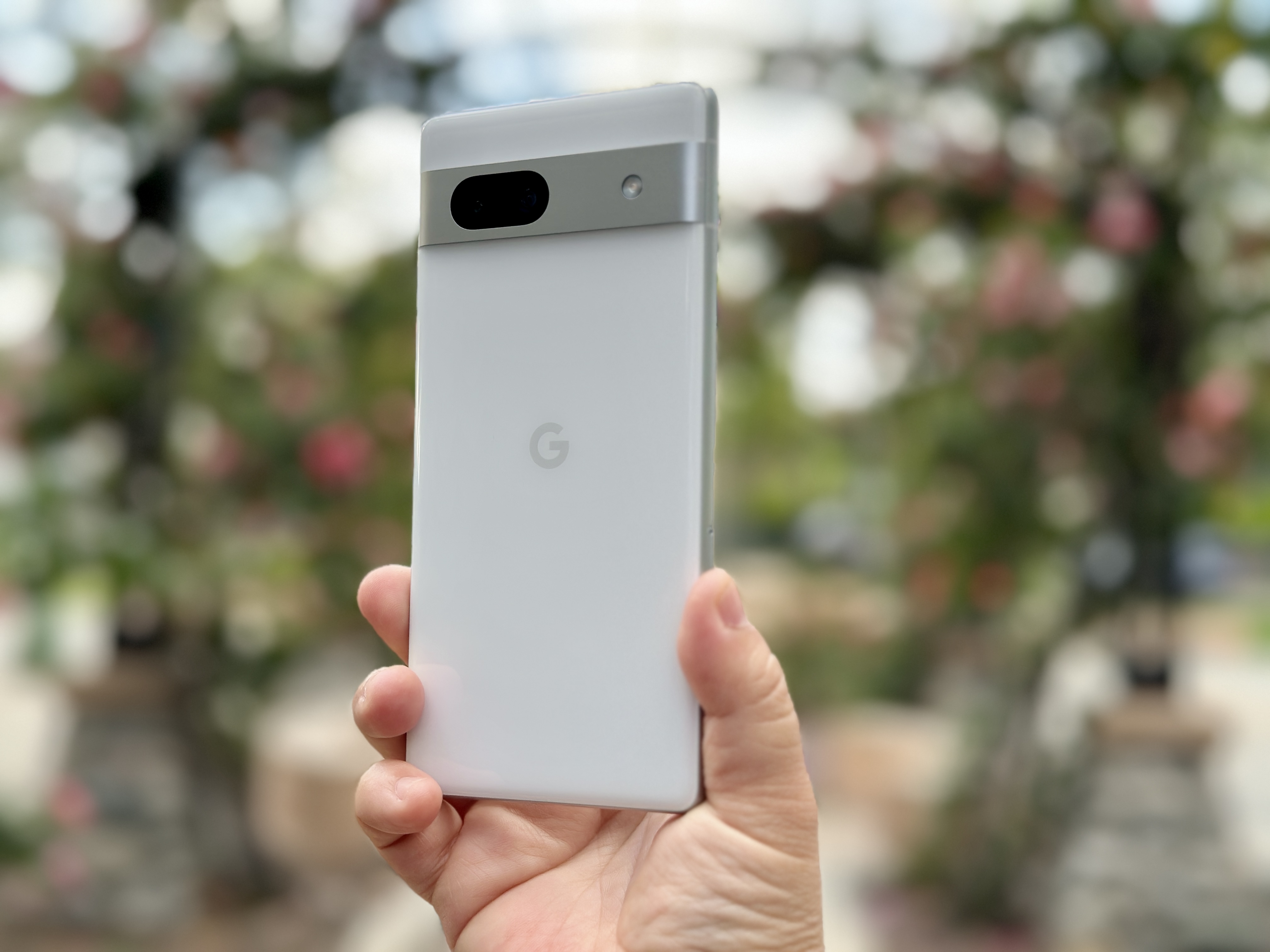 Google Pixel 7a in Snow in hand angled