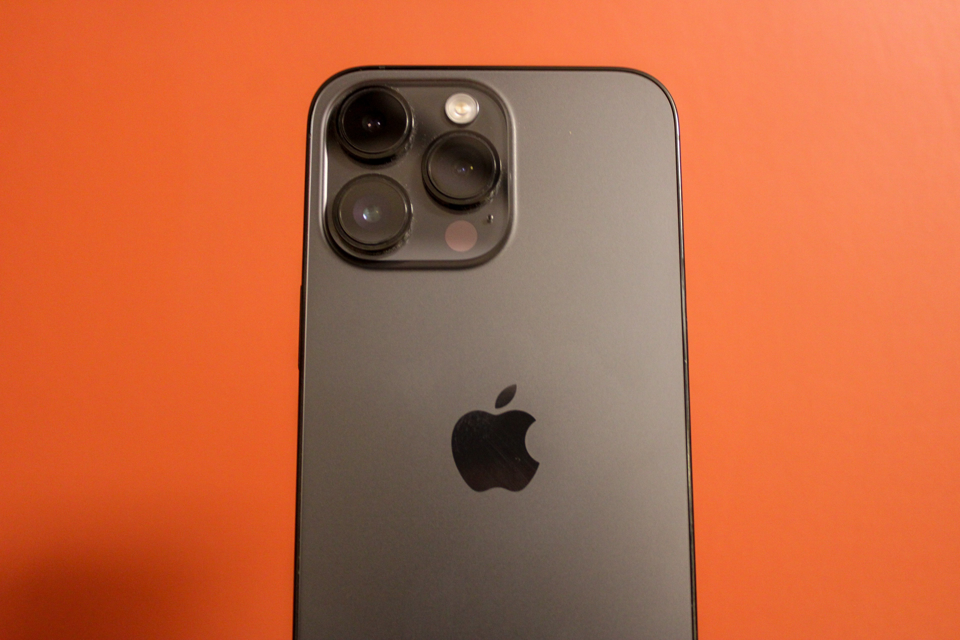 iPhone 14 Pro Max contra um fundo vermelho.
