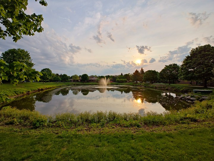 Photo of a sunset over a pond with a fountain, taken with the Motorola Edge Plus (2023).