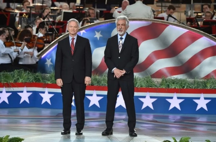 Two men stand on a stage in the National Memorial Day concert.