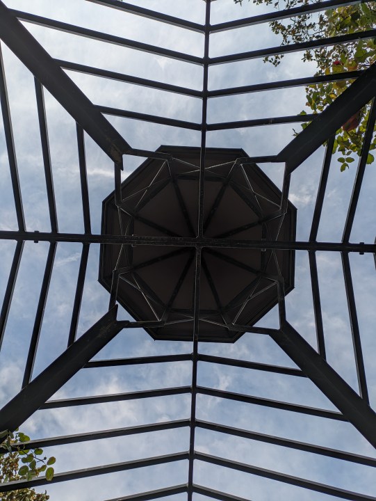 Metal canopy with sky peeking through taken with Google Pixel 7a main camera
