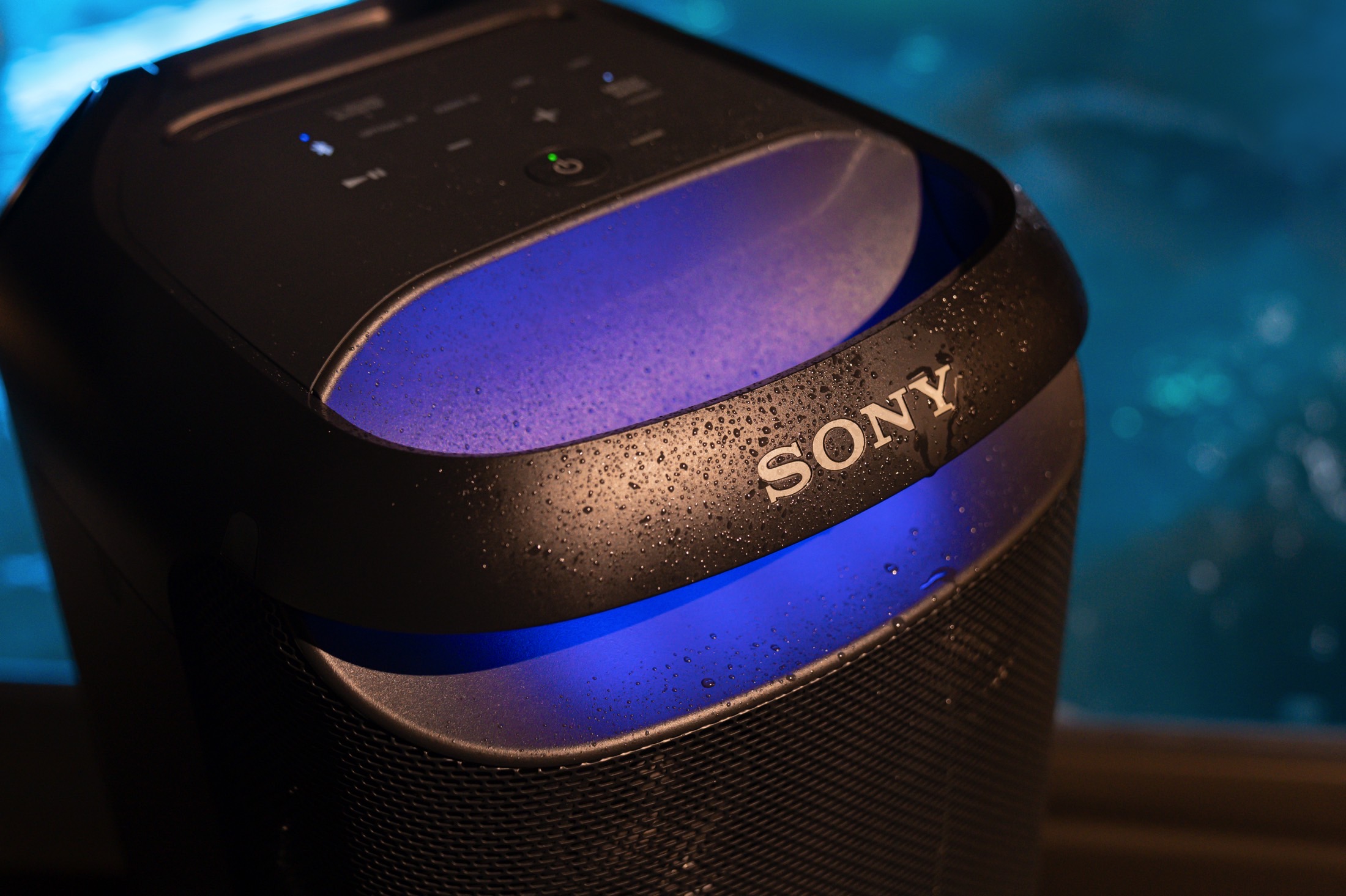 Parte superior da Sony SRS-XV800 com gotas de água e luzes acesas.