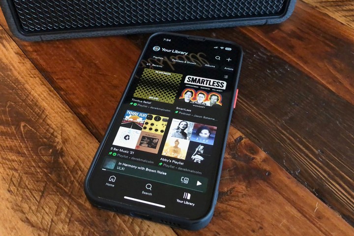 An iPhone with the Home section of the Spotify app on it.