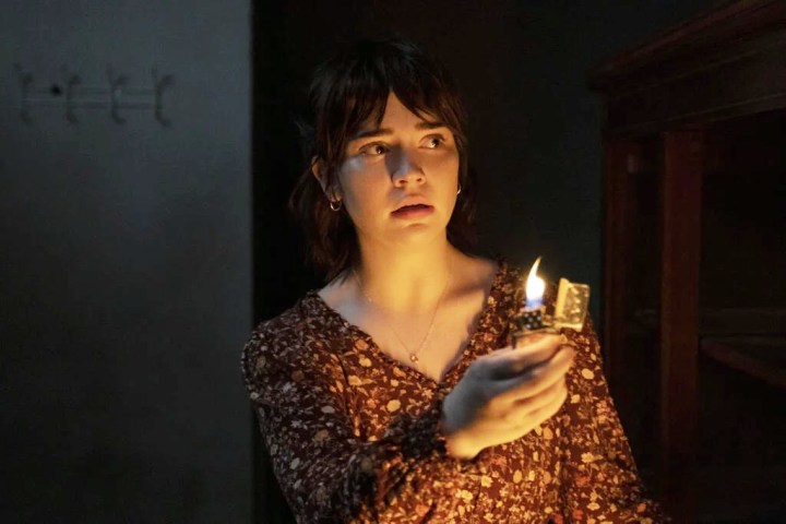 A young woman holds a lighter in front of her in The Boogeyman.
