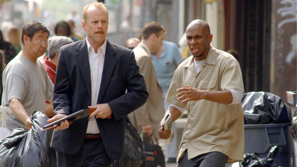 Bruce Willis segura uma arma ao lado de Mos Def em 16 blocos.