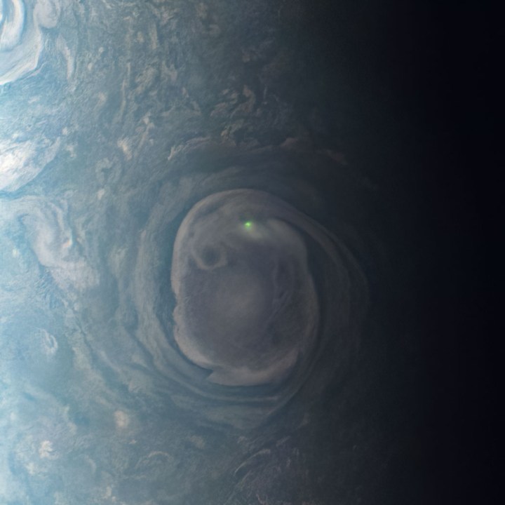 El resplandor de un rayo cerca de un vórtice cerca del polo norte de Júpiter.