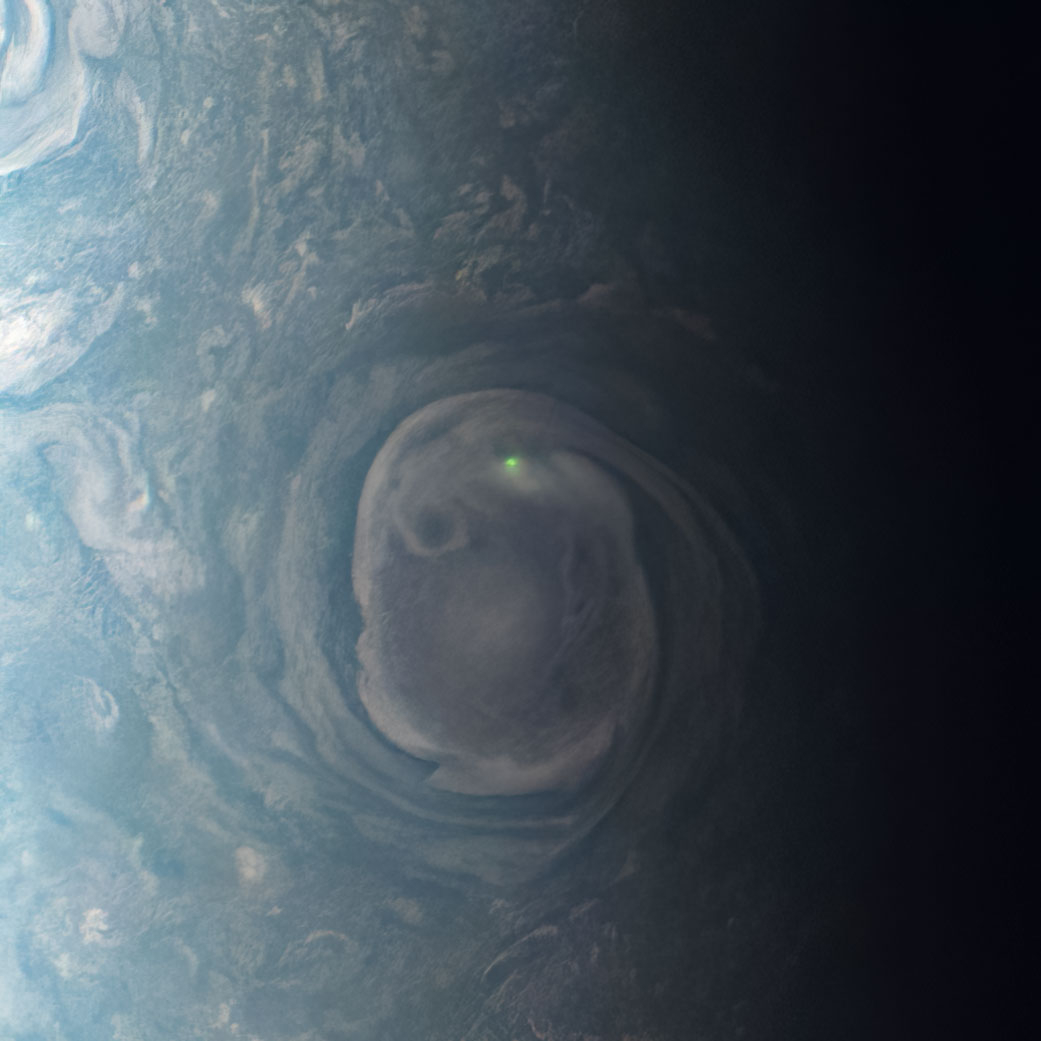 O brilho de um raio perto de um vórtice perto do pólo norte de Júpiter.