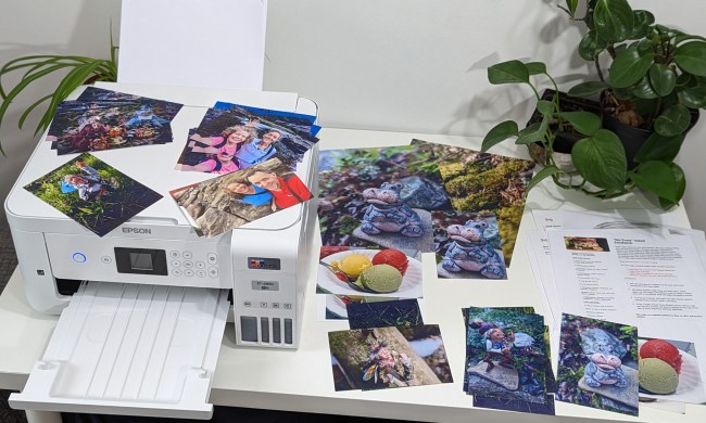 A printer surrounded by several printed photos.