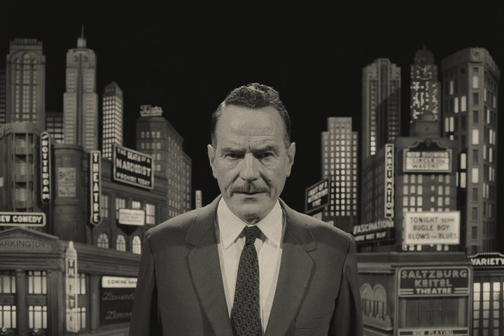 Bryan Cranston stands in front of a city set in Asteroid City.