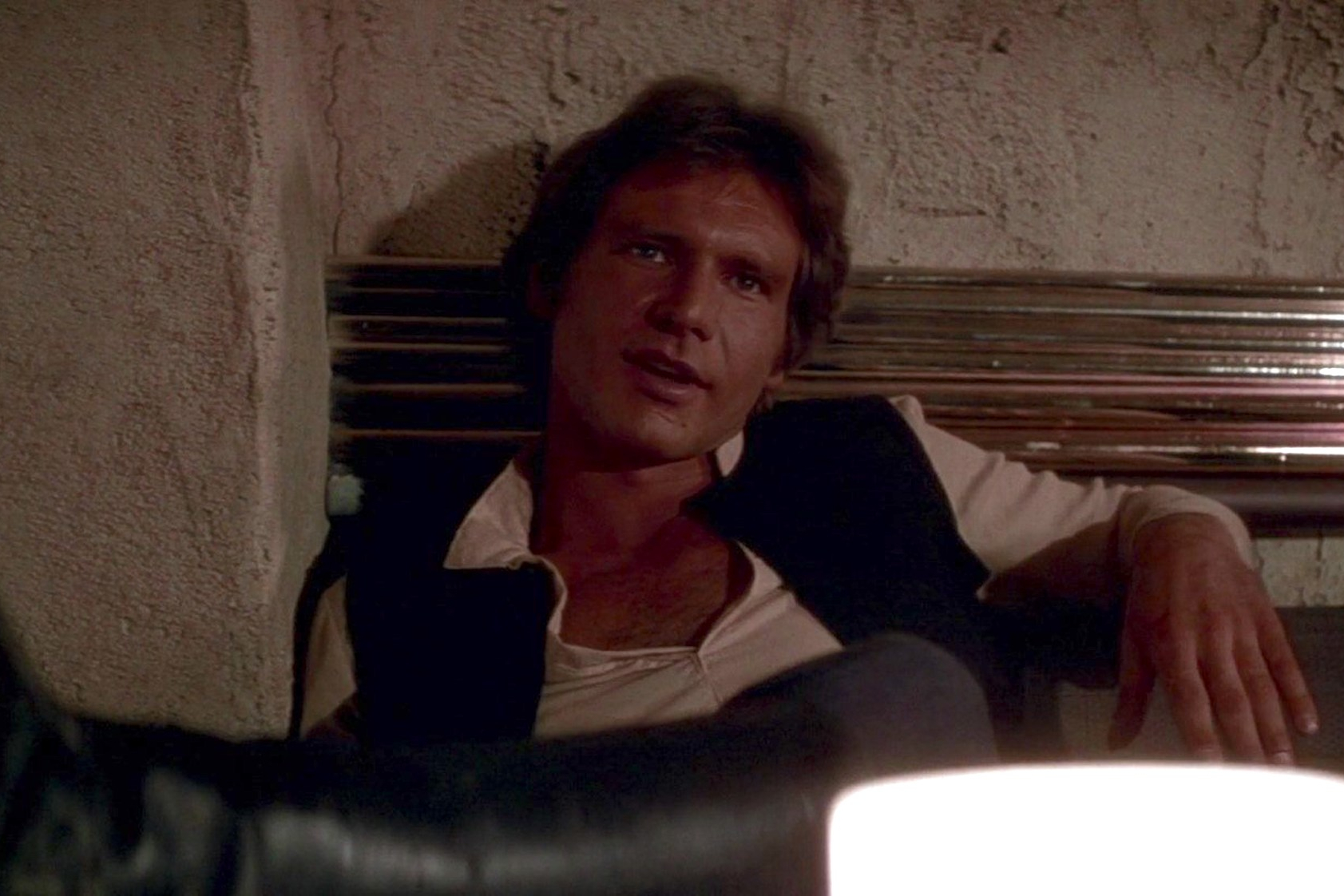 Han Solo se reclina em uma cabine de cantina em Star Wars: Uma Nova Esperança.