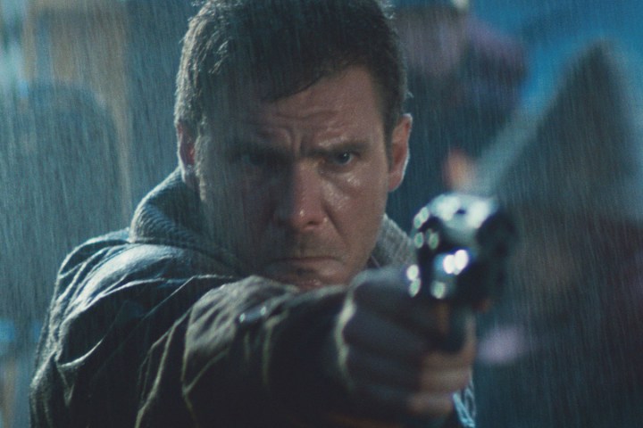 Harrison Ford points a gun in the rain in Blade Runner.