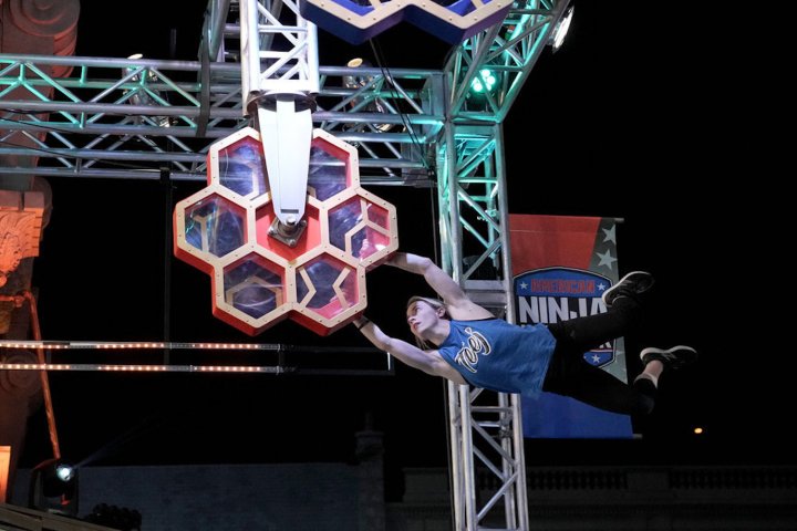 A woman holds onto an obstacle in American Ninja Warrior.