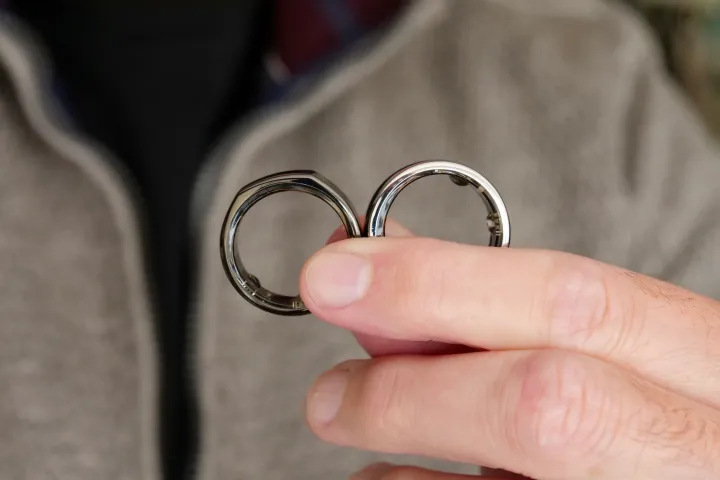 A person holding the Oura Ring 3rd generation Horizon and Heritage model.