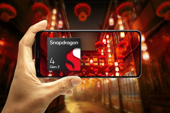 Рука держит телефон в альбомной ориентации, фокусируясь на иллюстрированной сцене китайских фонариков с Qualcomm. Snapdragon 4 логотипа второго поколения.