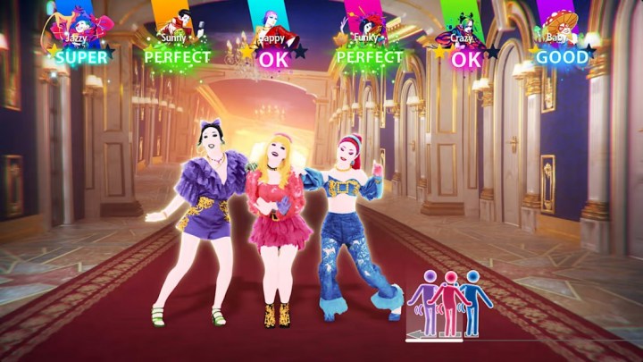 3 women in Just Dance 2023 stand close together at the center of the shot, performing a group dance move.