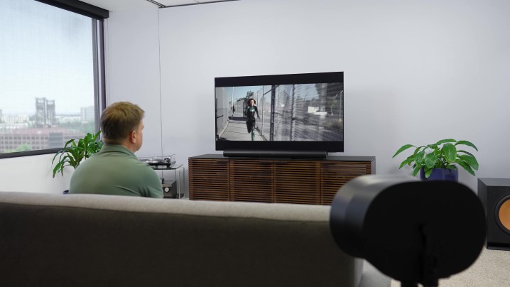 Ένας άντρας παρακολουθεί μια ταινία σε ένα στούντιο με Sonos Era 300 σε περιβάλλον ήχου surround.