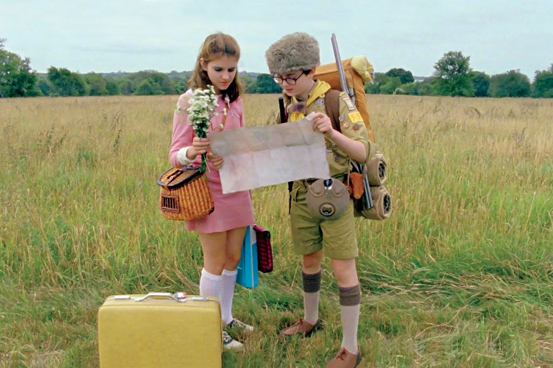 Suzy and Sam stand in a field together in Moonrise Kingdom.