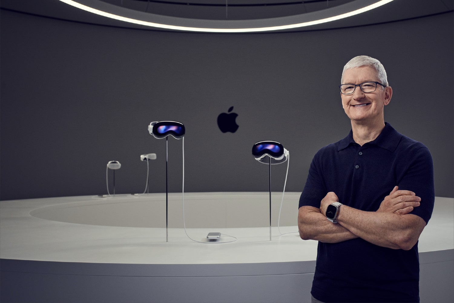 O CEO da Apple, Tim Cook, em frente a quatro headsets Vision Pro.