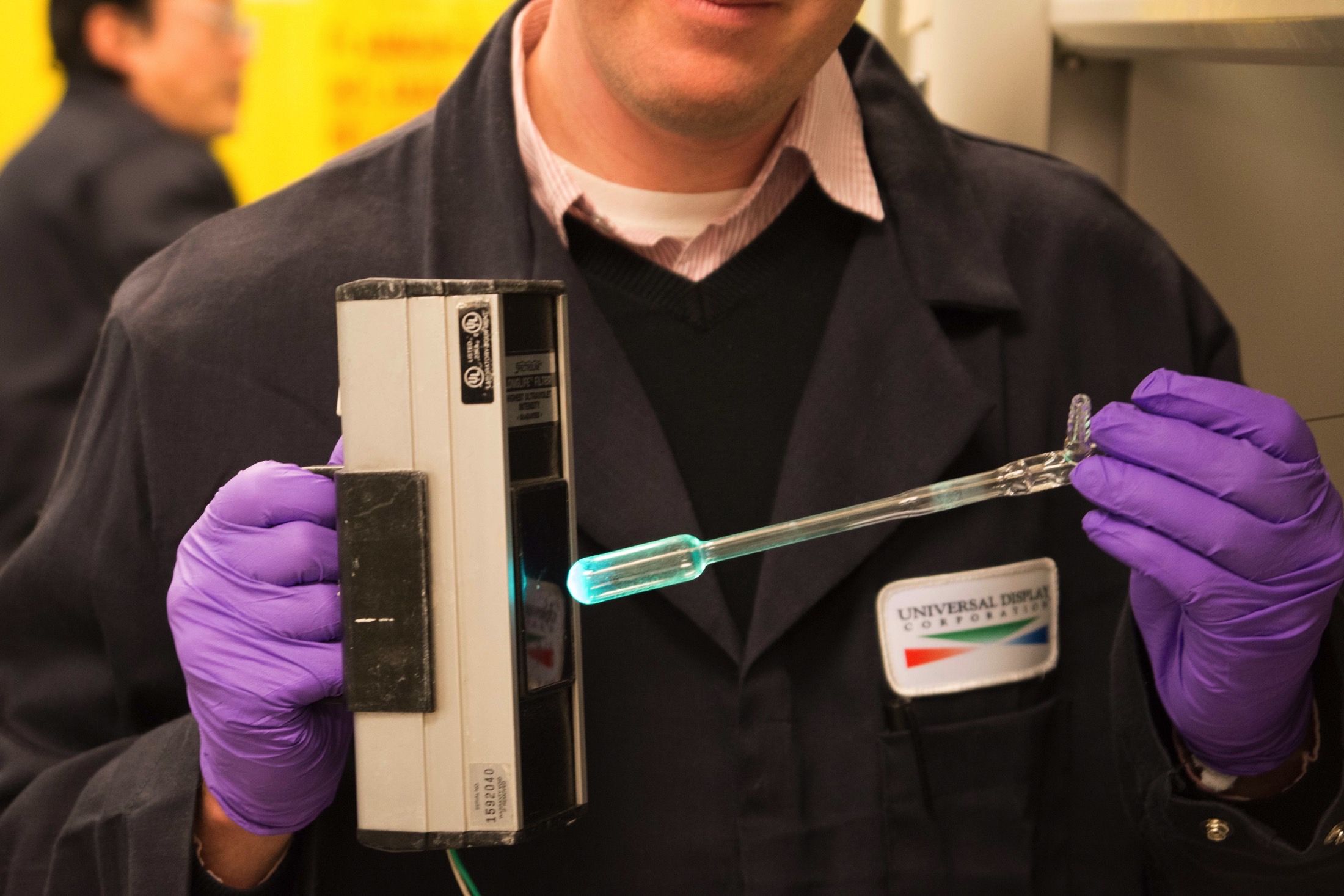 Químico da Universal Display Corporation iluminando materiais OLED azuis fosforescente em desenvolvimento no laboratório de P&D.