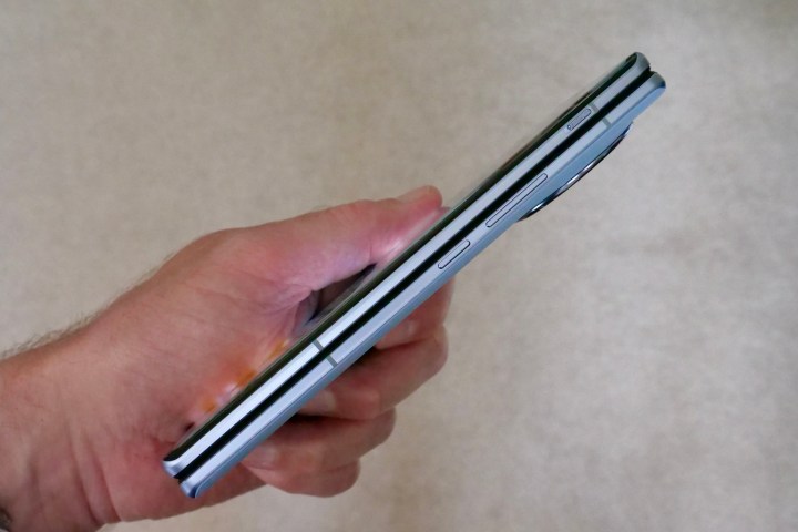 Uma pessoa segurando o Vivo X Fold 2 e mostrando a lateral do aparelho.