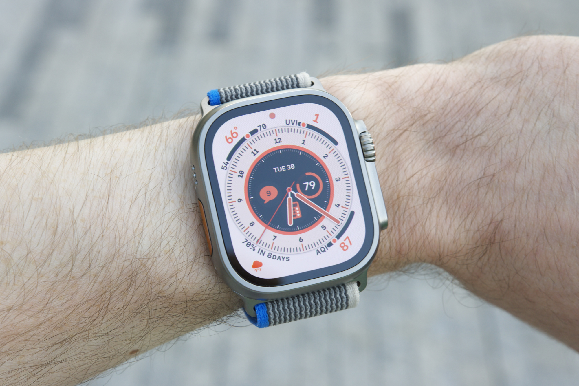 Someone wearing the Apple Watch Ultra with the Wayfinder face.