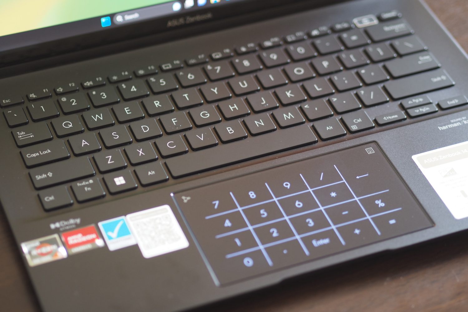 Vista superior do Asus ZenBook 14 OLED mostrando o teclado numérico LED.
