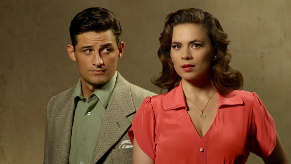 Um homem olha para uma mulher em Agent Carter.