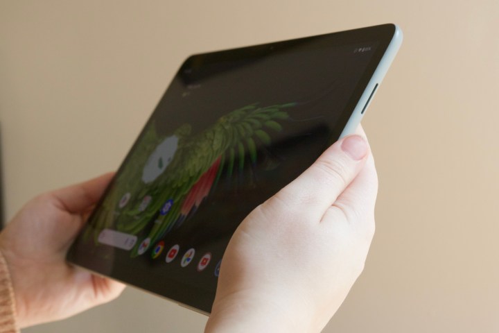 कोई व्यक्ति Google Pixel टैबलेट को चालू डिस्प्ले के साथ पकड़े हुए है।