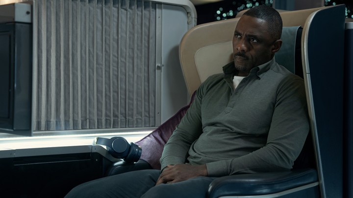 Sam sitting on his seat on the plane looking upset in a scene from Hijack on Apple TV+.