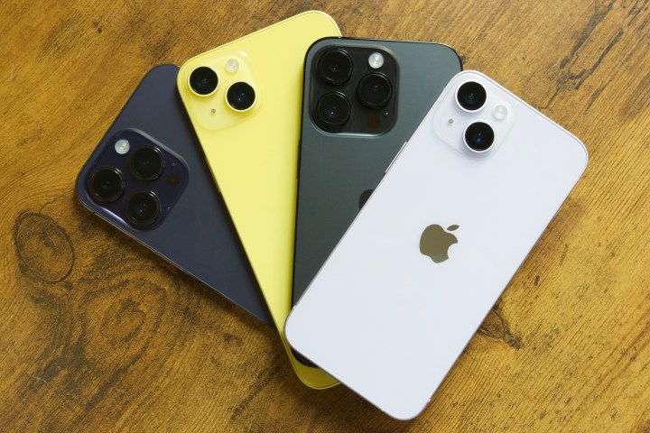 The iPhone 14, iPhone 14 Plus, iPhone 14 Pro, and iPhone 14 Pro Max all lying on a table.