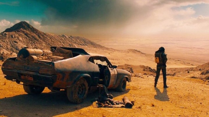 A man stands in front of his car in Mad Max: Fury Road.
