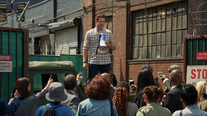 Ben with a bullhorn addressing the public in a scene from Manifest.