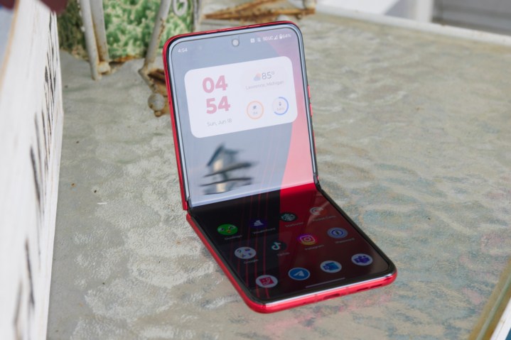The Motorola Razr Plus half-opened and sitting on a glass table.
