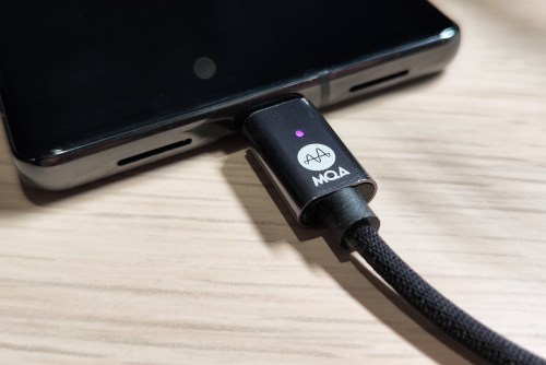 A Zorloo Ztella MQA USB DAC plugged into a Google Pixel 7 Pro, showing the MQA logo and a magenta LED light.
