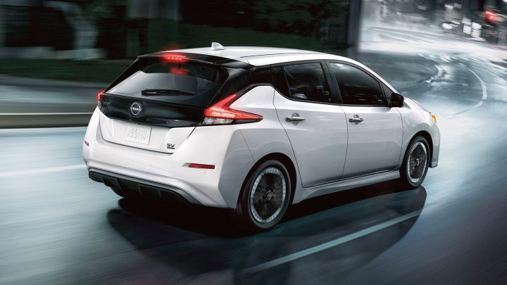 Um Nissan Leaf 2023 em uma estrada urbana chuvosa. 