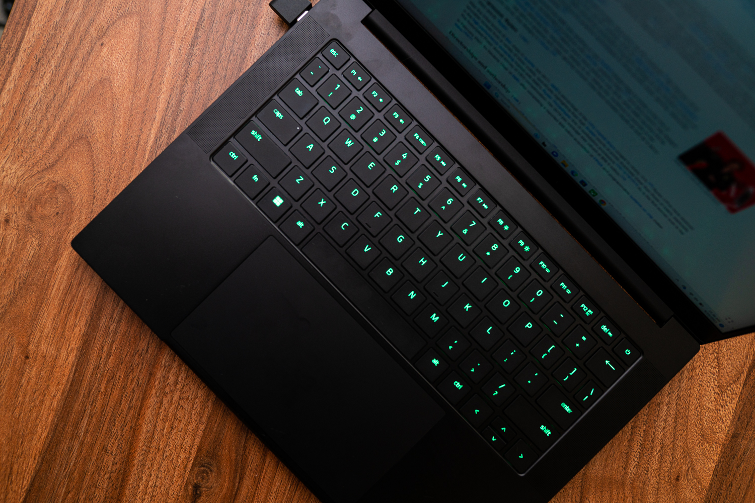 The keyboard of the Razer Blade 14 on a wooden table.