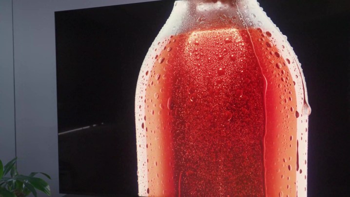 Contas de condensação em uma garrafa de vidro contendo líquido vermelho em um TCL QM8.