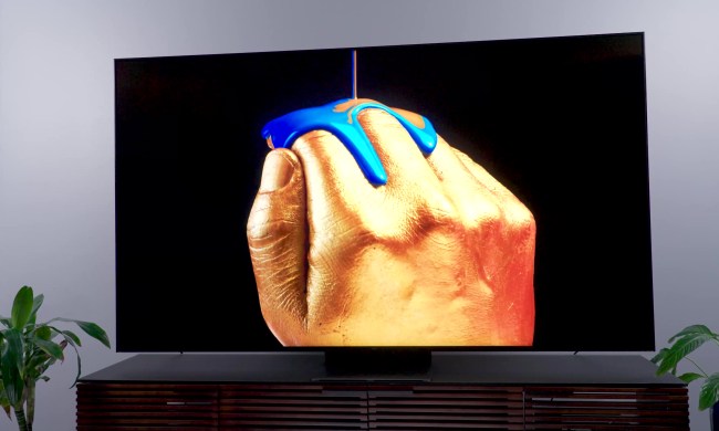 A stylized image of metallic blue paint being poured over hand shown on a a TCL QM8.