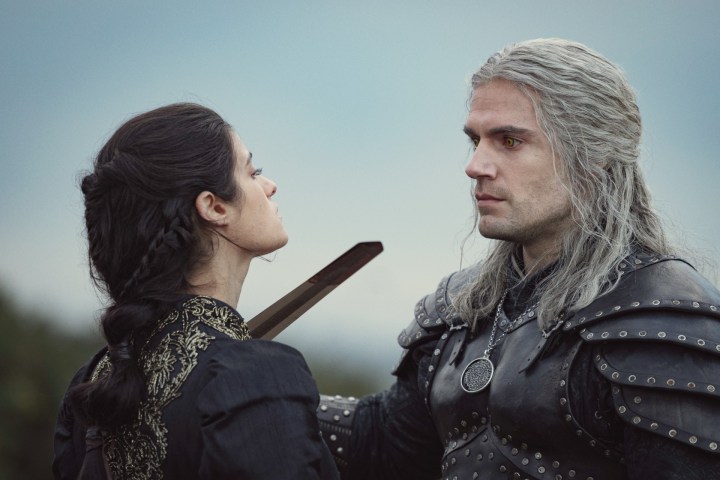 Um homem segura uma espada na garganta de uma mulher em The Witcher.