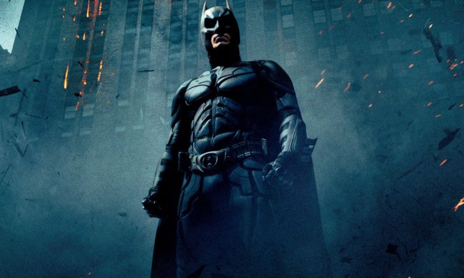 Batman stands in a cloud of ash and rubble in a poster for The Dark Knight.